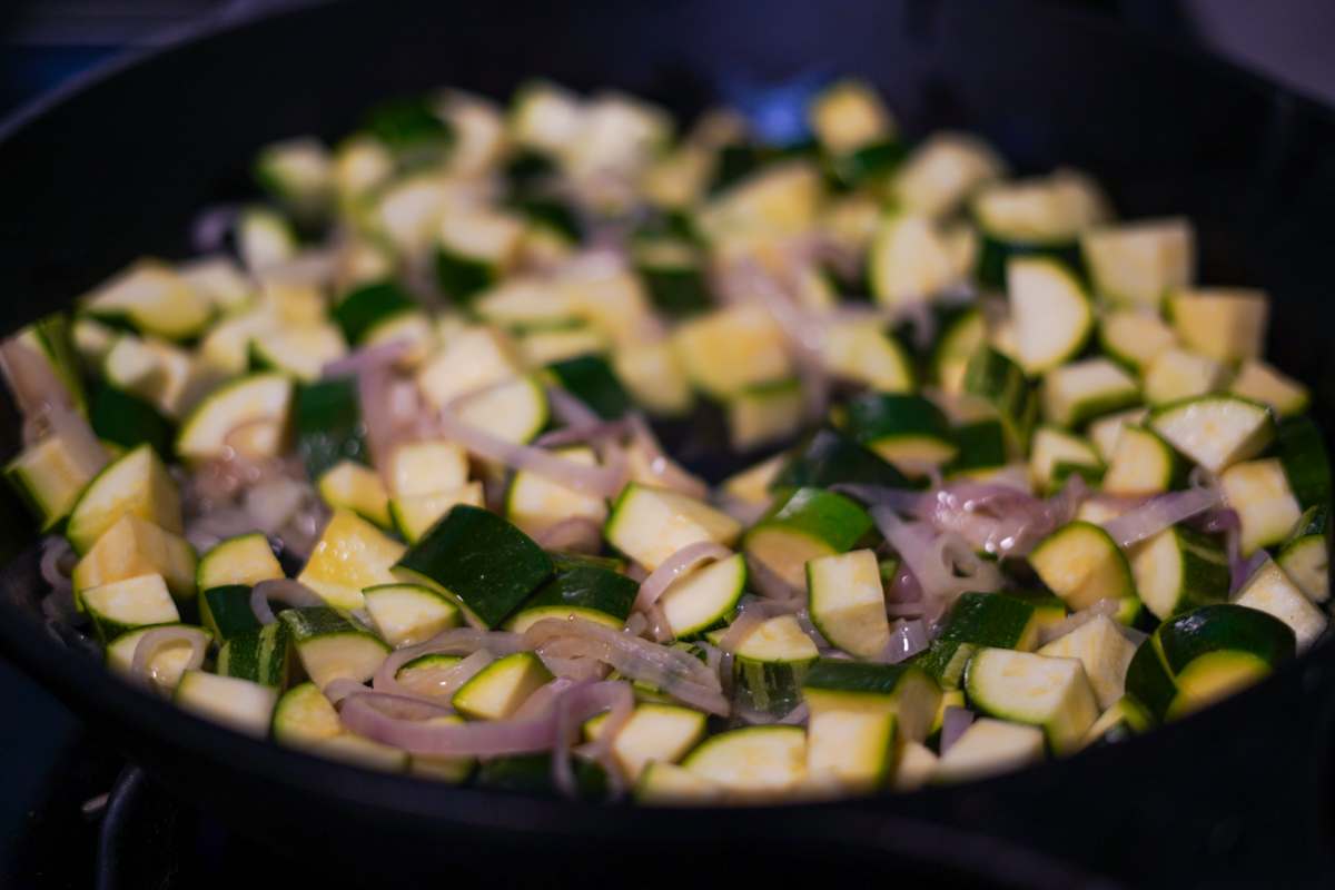 Squash and shallots cooking in a pan